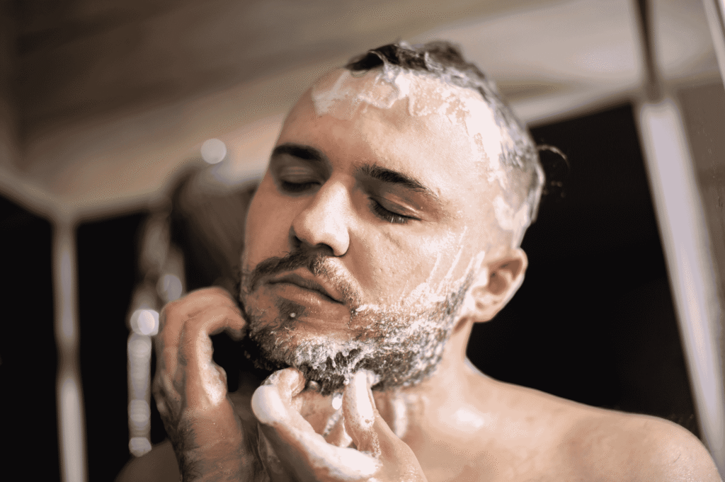 Itchy scalp after workouts—man washing hair and beard after gym session, a common hygiene routine in hot climates.